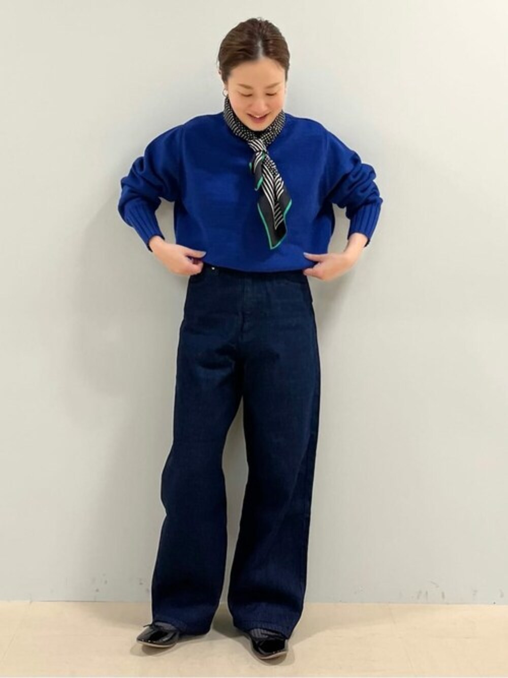 ブルー系のニット/セーター、ブルー系のデニムパンツ、ブラック系のパンプスを着用したレディースの冬コーディネートの1枚目の写真