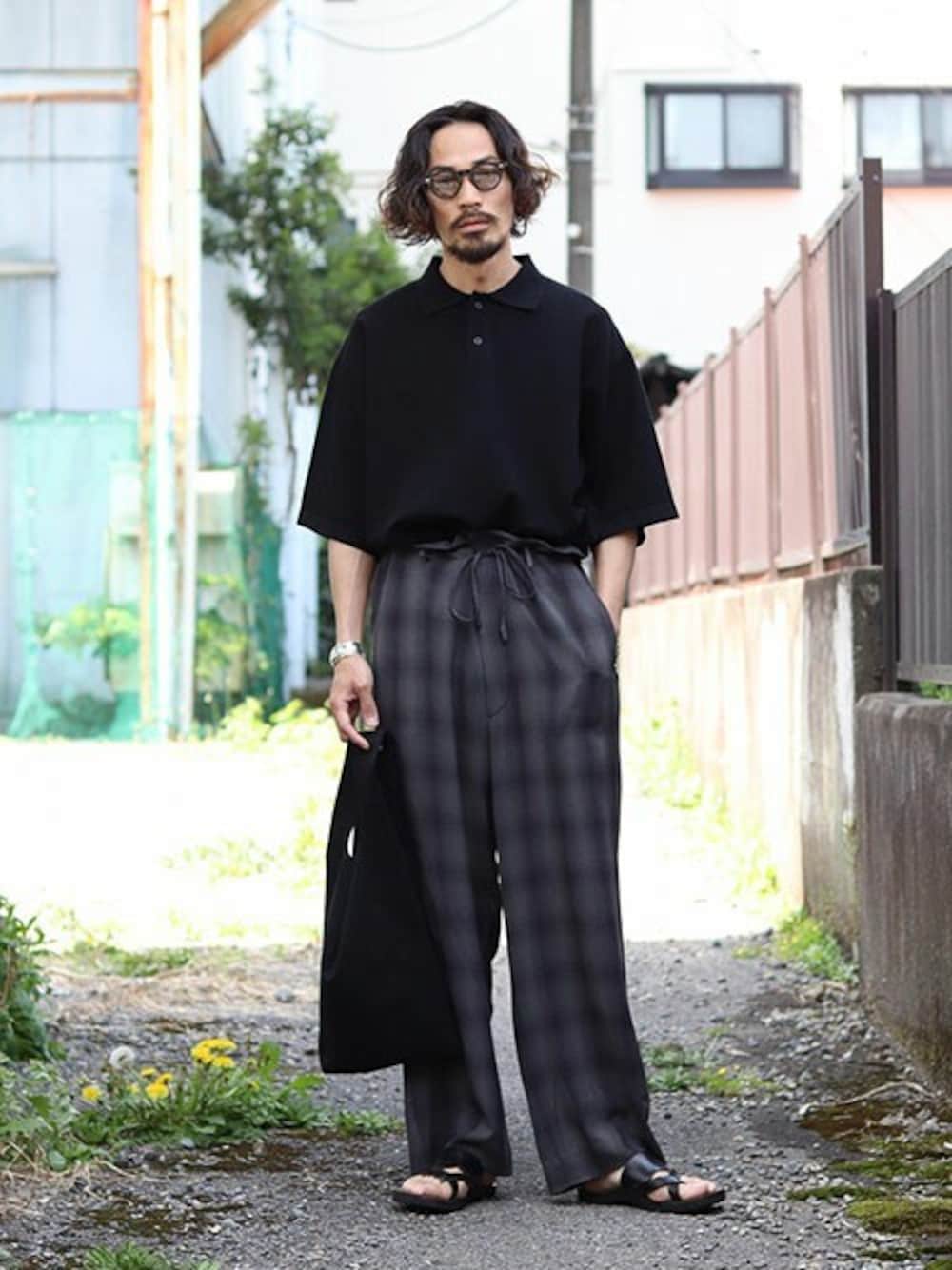 ブラック系のトートバッグ、ブラック系のポロシャツを着用したメンズの春コーディネートの1枚目の写真