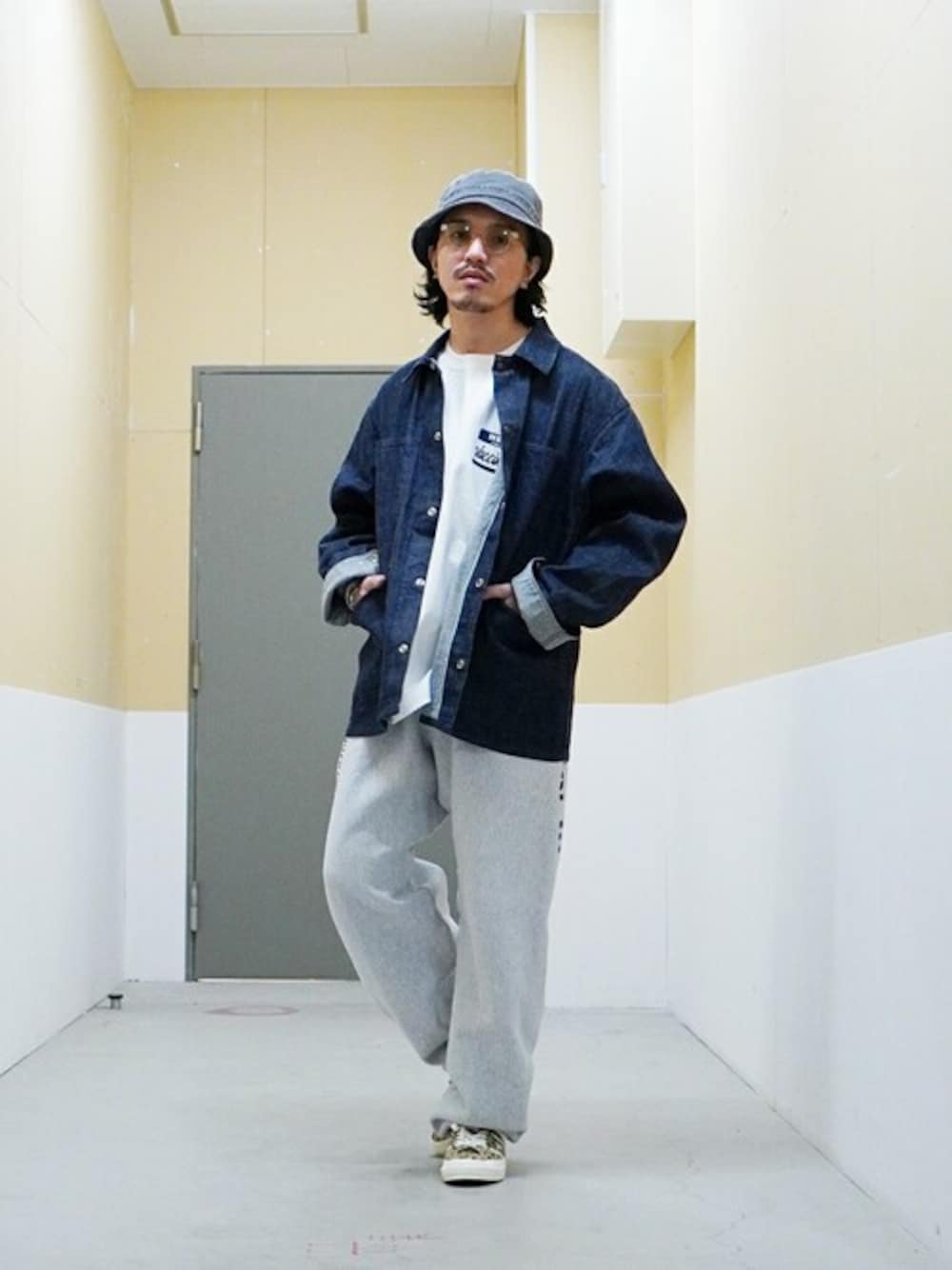ブルー系のデニムジャケット、グレー系のハットを着用したメンズの春コーディネートの1枚目の写真