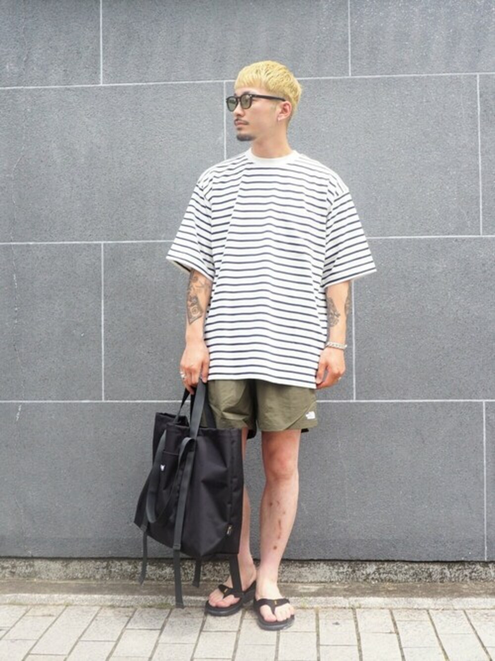 ブラック系のTシャツ/カットソーを着用したメンズの夏コーディネートの1枚目の写真