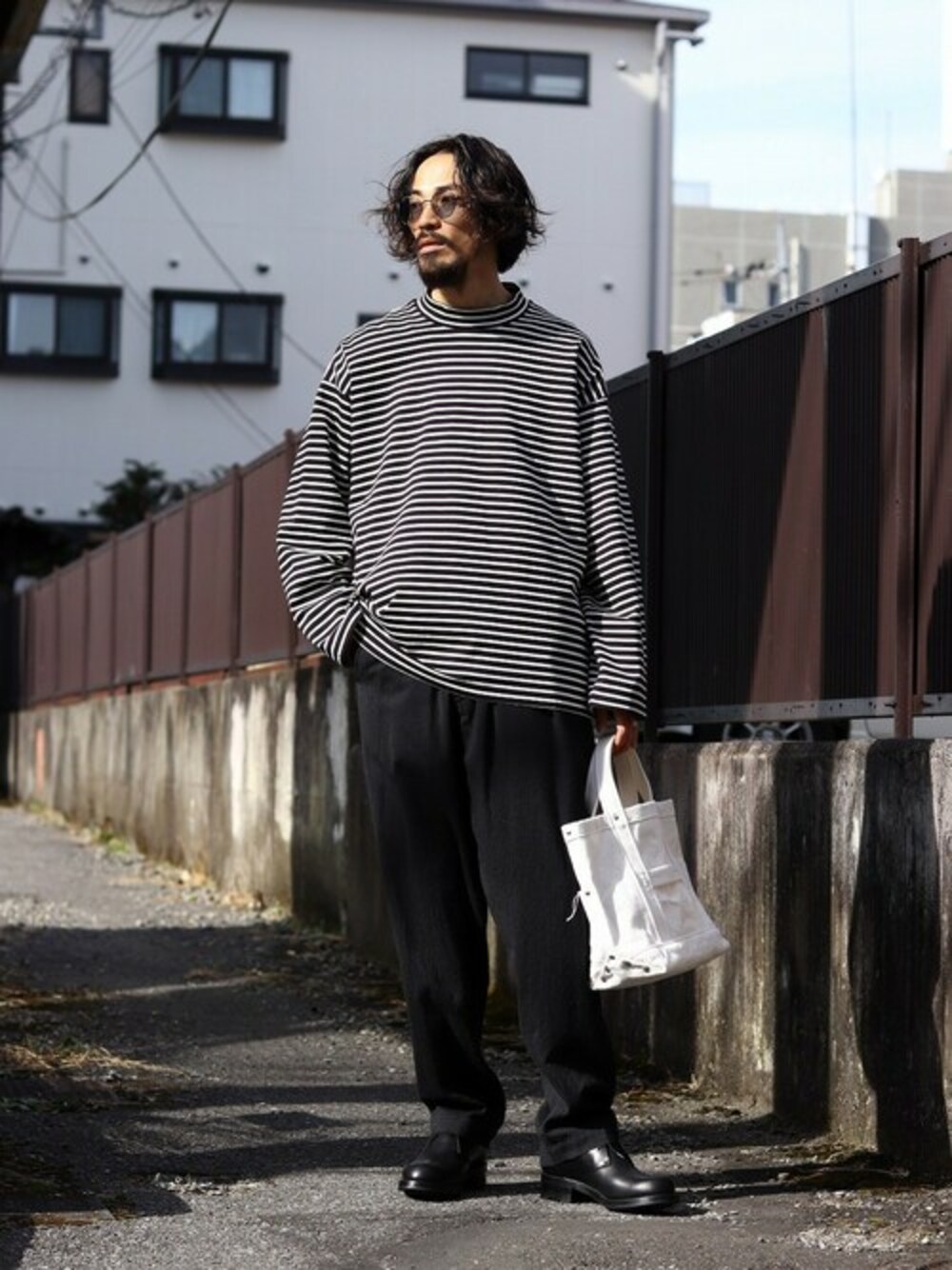 ブラック系のTシャツ/カットソーを着用したメンズの秋コーディネートの1枚目の写真