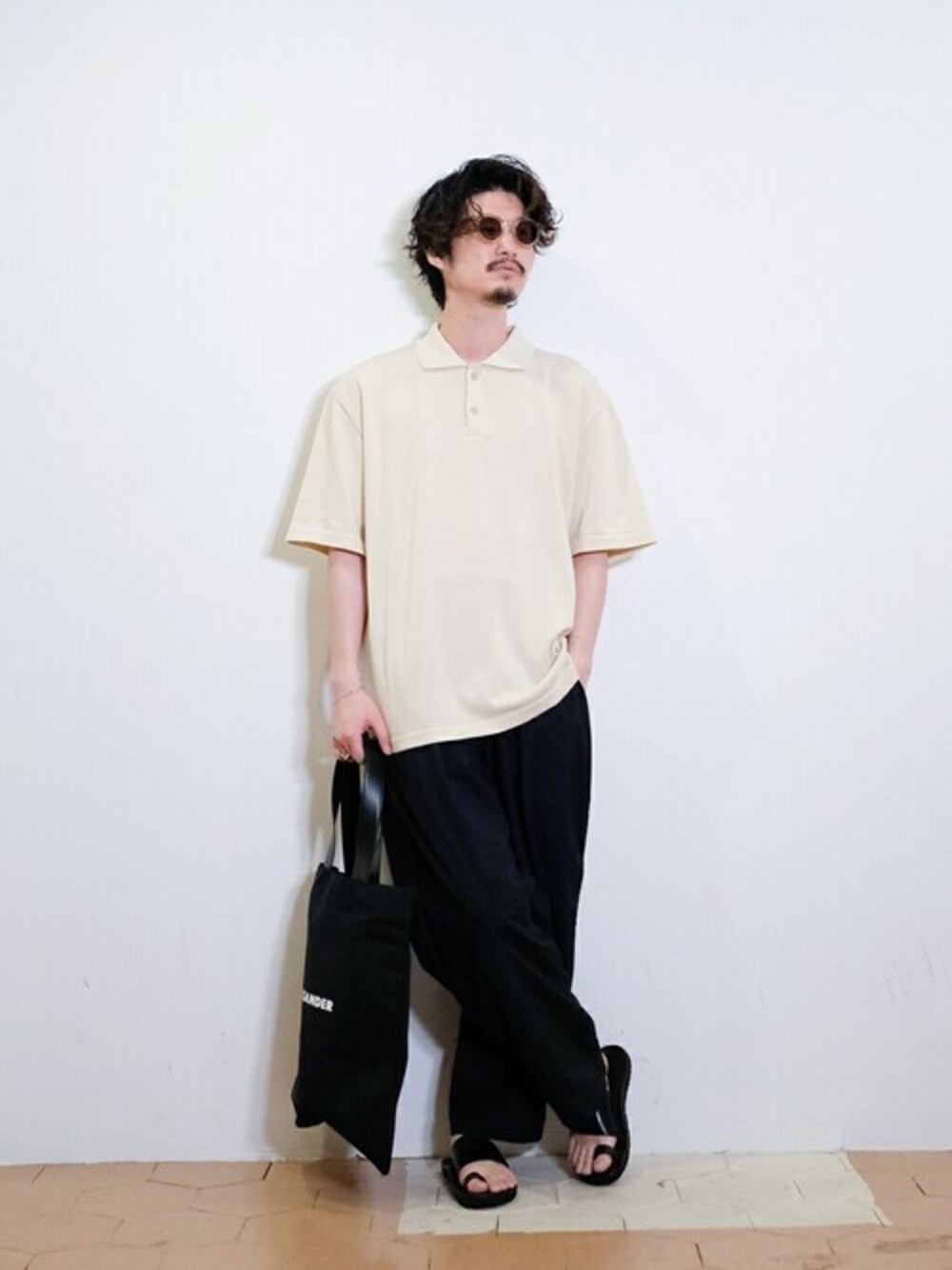 ベージュ系のポロシャツを着用したメンズの夏コーディネートの1枚目の写真
