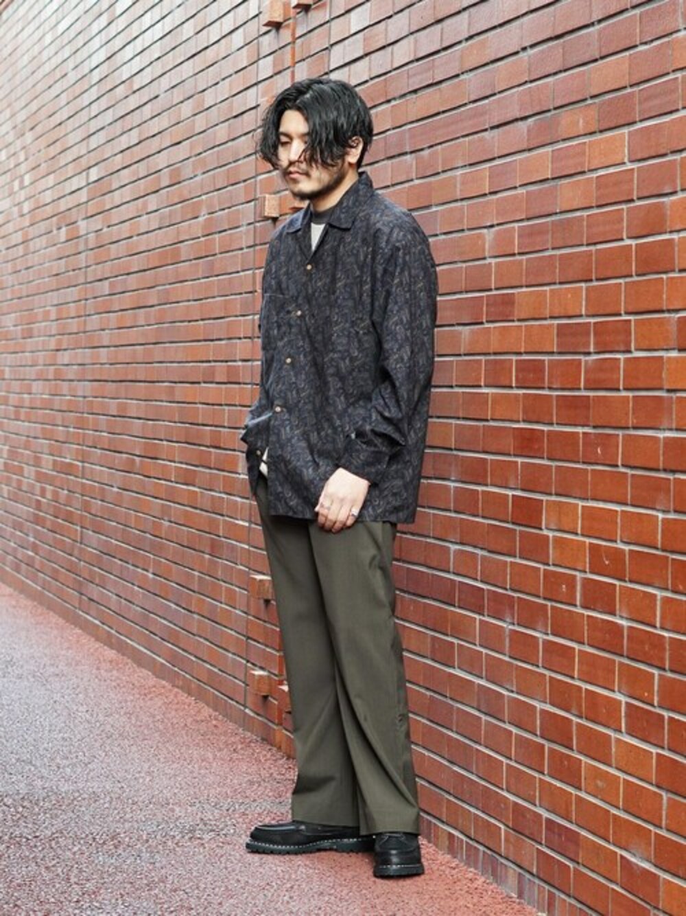 ブラック系のシャツ/ブラウス、ベージュ系のTシャツ/カットソー、ブラウン系のスラックスを着用したメンズの春コーディネートの1枚目の写真