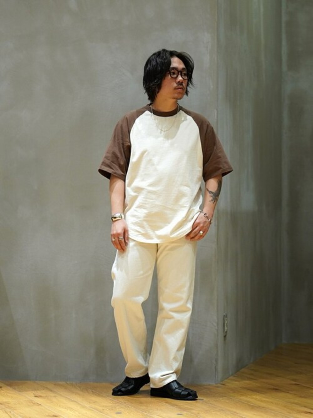 ブラウン系のTシャツ/カットソーを着用したメンズの春コーディネートの1枚目の写真