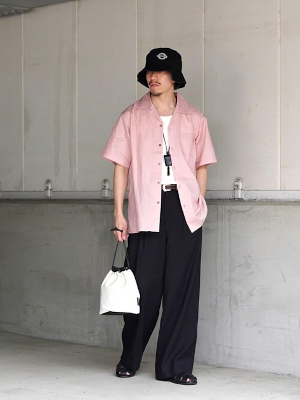 ピンク系のシャツ/ブラウス、ベージュ系のハンドバッグを着用したメンズの春コーディネートの1枚目の写真