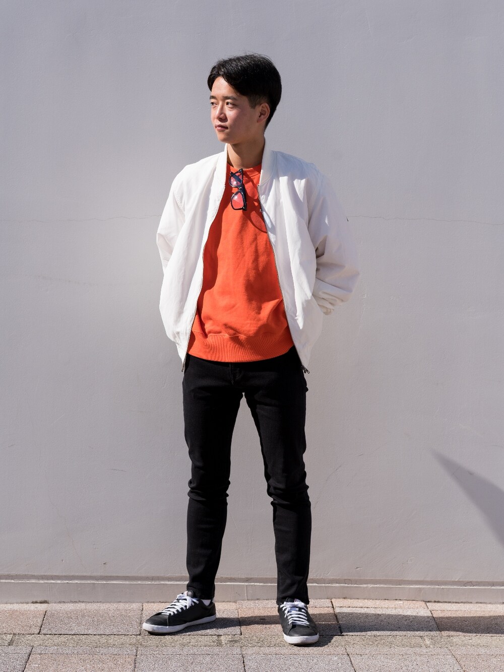 ブラック系のデニムパンツ、オレンジ系のその他トップス、ホワイト系のその他トップスを着用したメンズの冬コーディネートの3枚目の写真