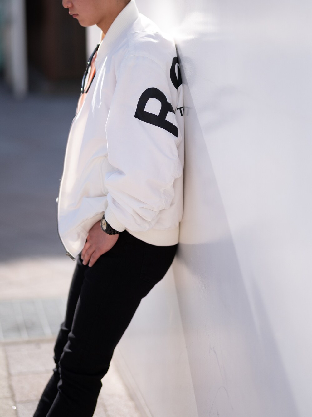 ブラック系のデニムパンツ、オレンジ系のその他トップス、ホワイト系のその他トップスを着用したメンズの冬コーディネートの2枚目の写真