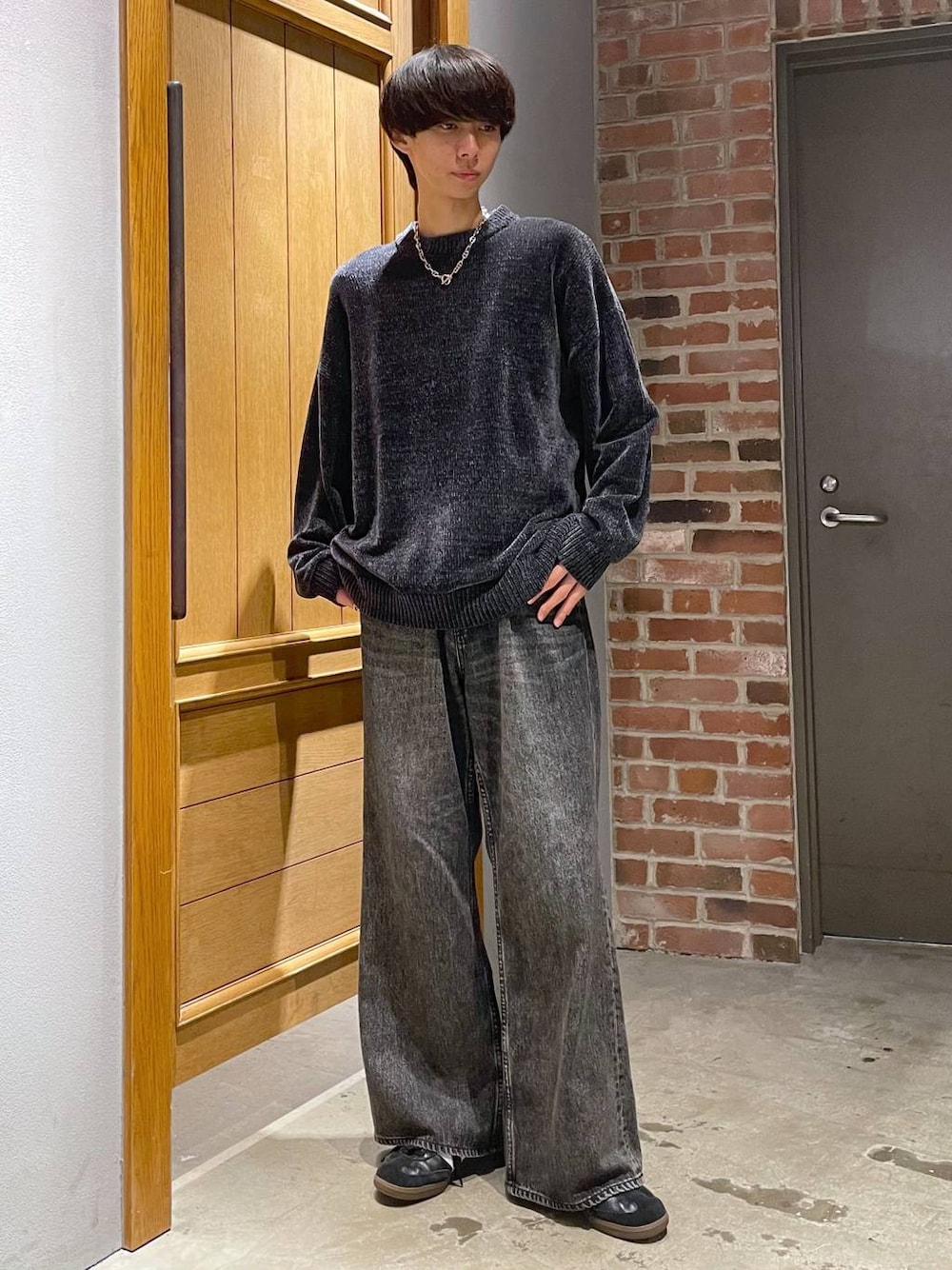 グレー系のデニムパンツ、ブラック系のニット/セーターを着用したメンズの秋コーディネートの1枚目の写真