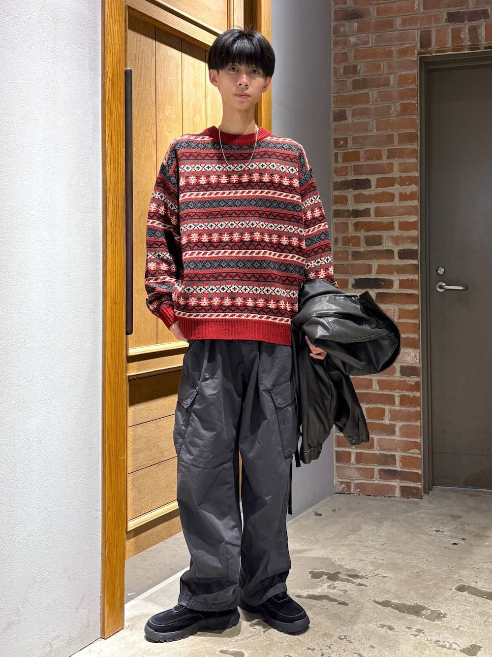 ブラック系のブルゾン、ブラック系のカーゴパンツ、ブラック系のスニーカーを着用したメンズの秋コーディネートの1枚目の写真