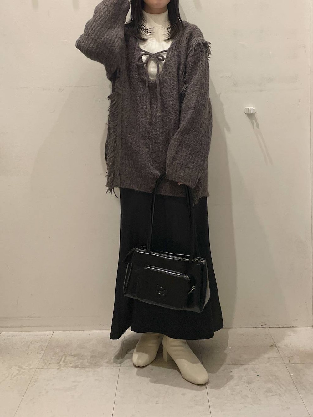 ホワイト系のニット/セーター、グレー系のニット/セーター、ホワイト系のブーツを着用したレディースの冬コーディネートの1枚目の写真