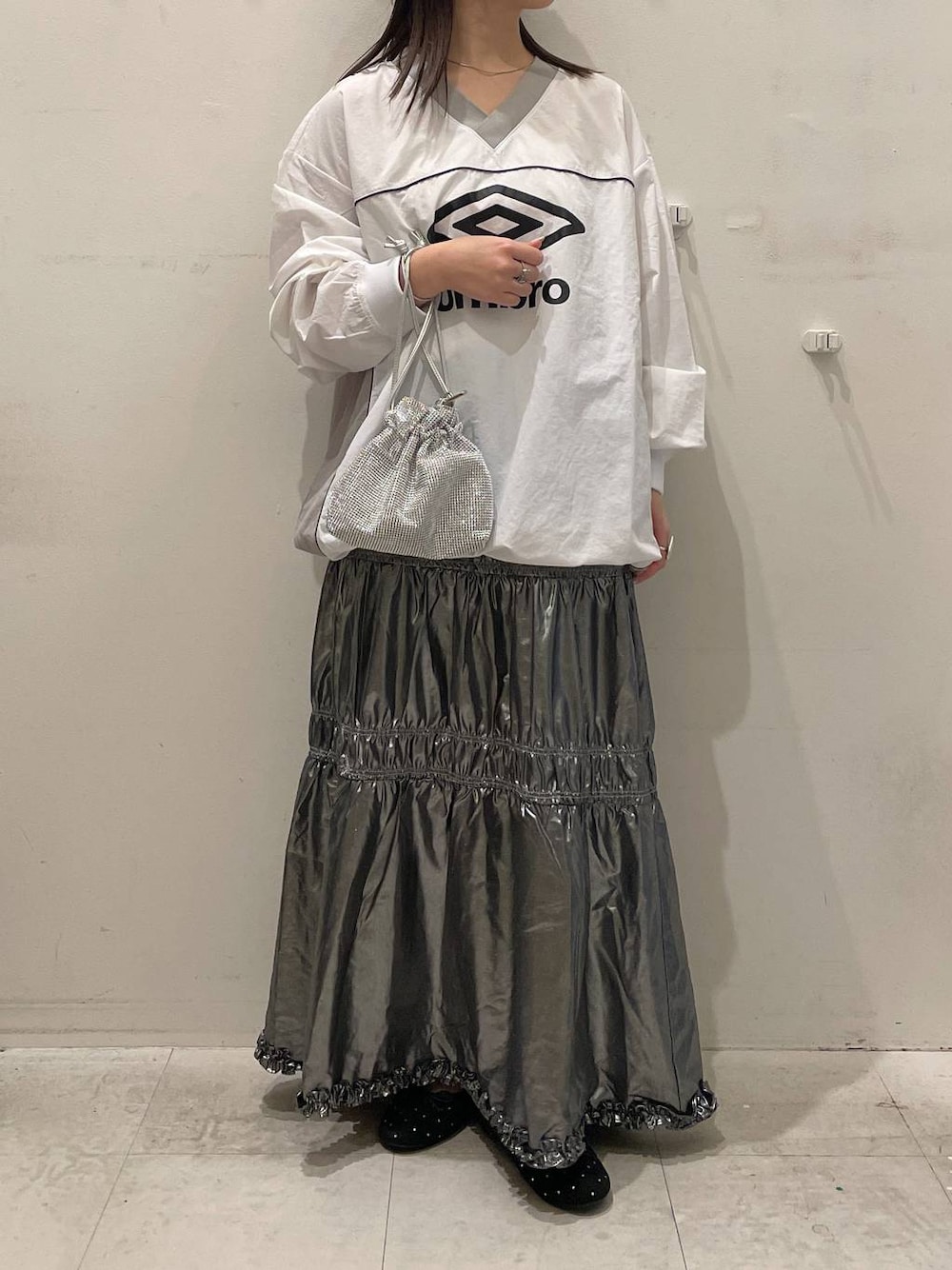 シルバー系のスカート、ブラック系のバレエシューズ、シルバー系のショルダーバッグを着用したレディースの秋コーディネートの1枚目の写真