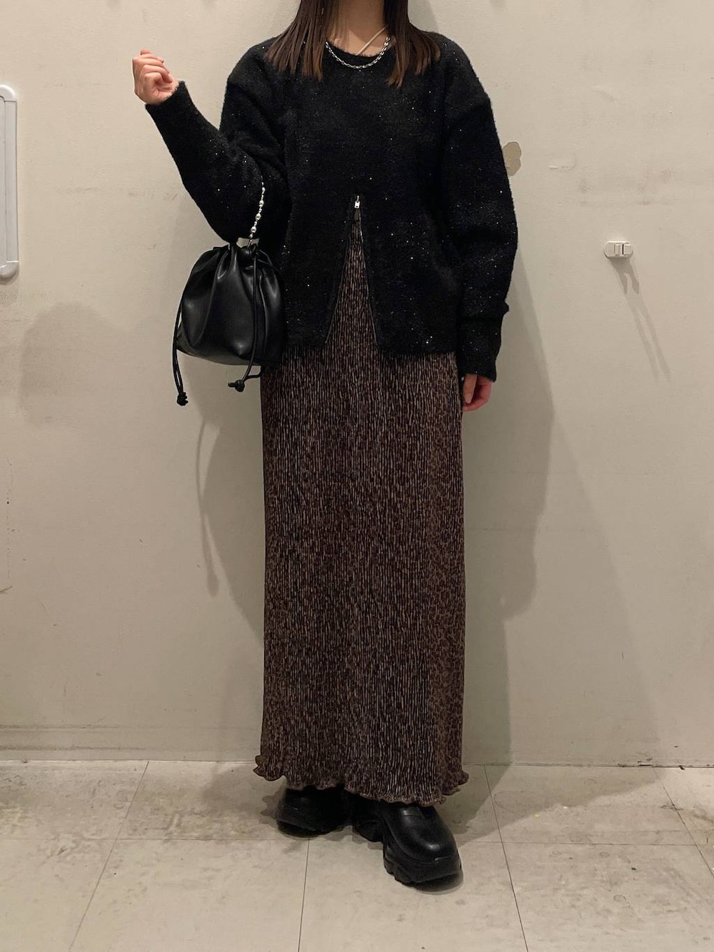 ブラック系のブーツ、ブラック系のショルダーバッグ、その他のスカートを着用したレディースの秋コーディネートの1枚目の写真