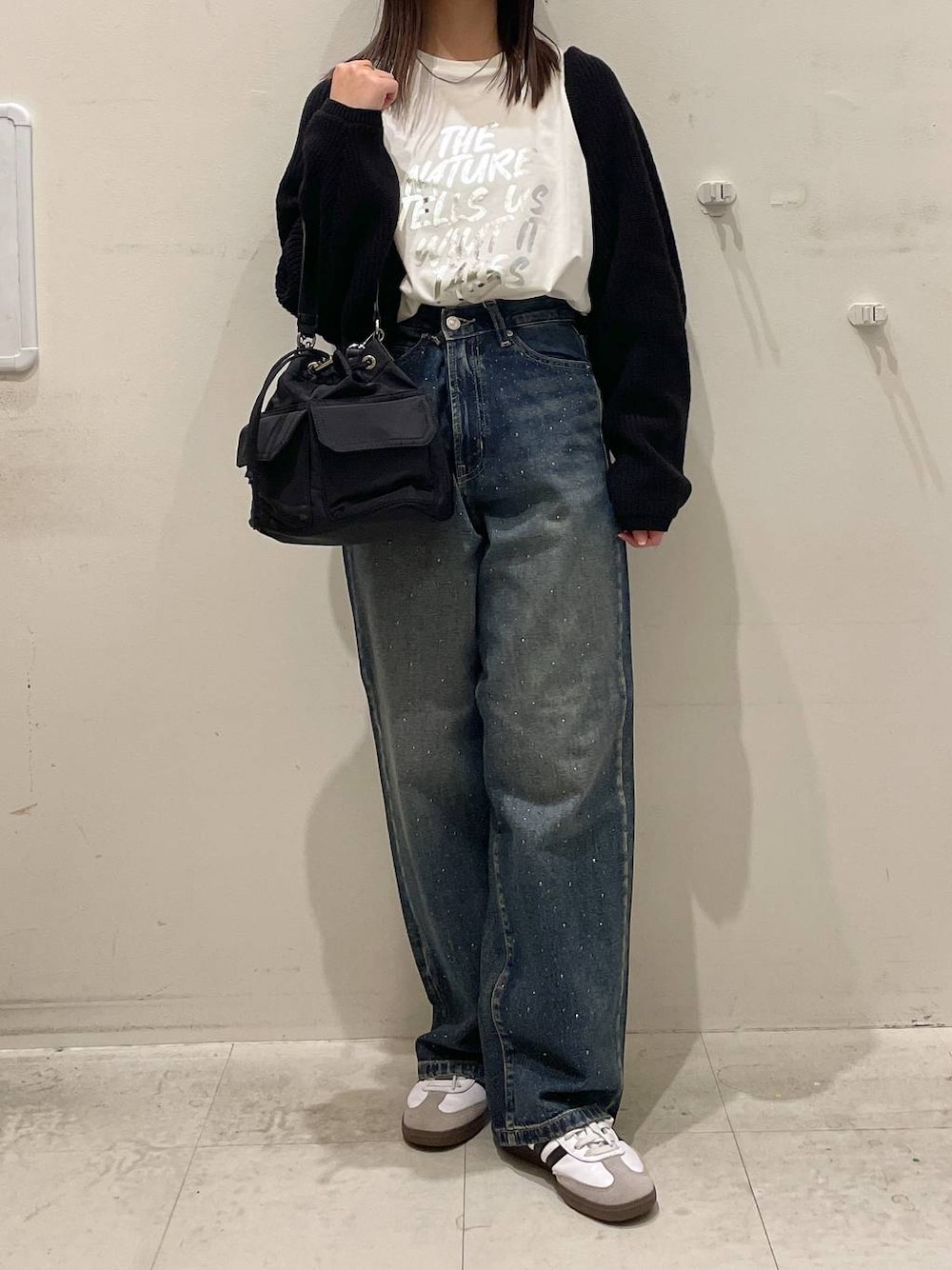 ホワイト系のTシャツ/カットソー、ブラック系のニット/セーター、ブラック系のショルダーバッグを着用したレディースの秋コーディネートの1枚目の写真