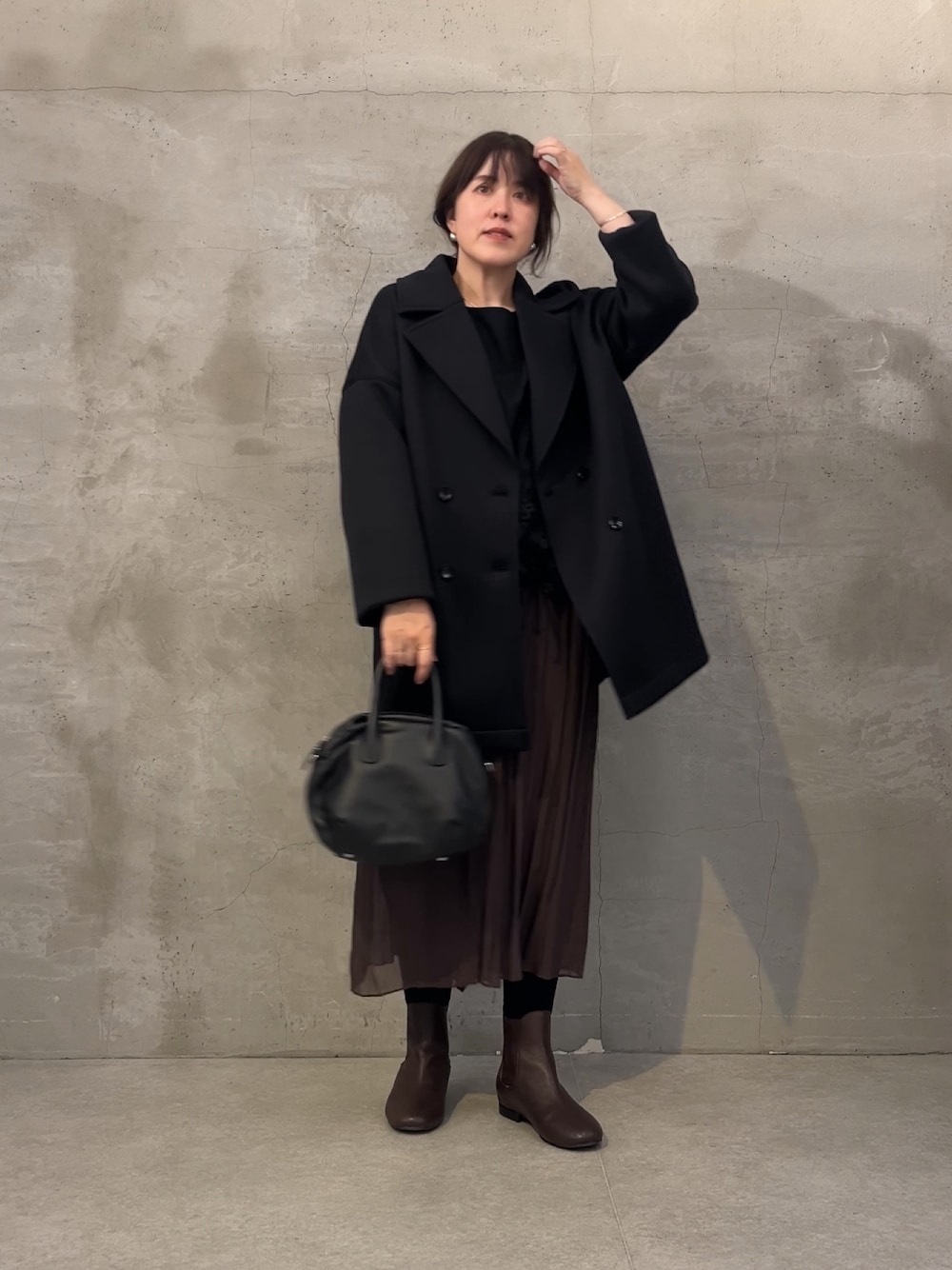 ブラック系のボストンバッグ、ブラウン系のその他パンツ、ブラウン系のブーツを着用したレディースの秋コーディネートの1枚目の写真