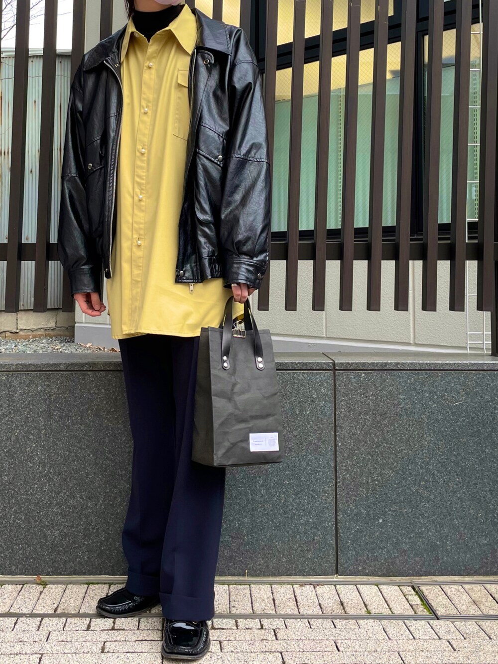 イエロー系のシャツ/ブラウス、ブラック系のジャケット/アウター、ブルー系のスラックスを着用したメンズの春コーディネートの1枚目の写真