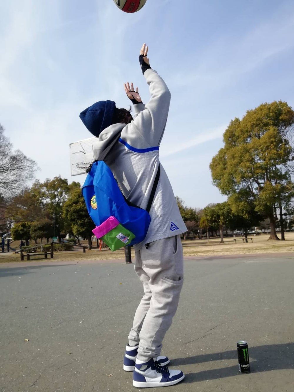 グレー系のタンクトップ、グレー系のパンツ、ブルー系のスニーカーを着用したメンズの春コーディネートの2枚目の写真