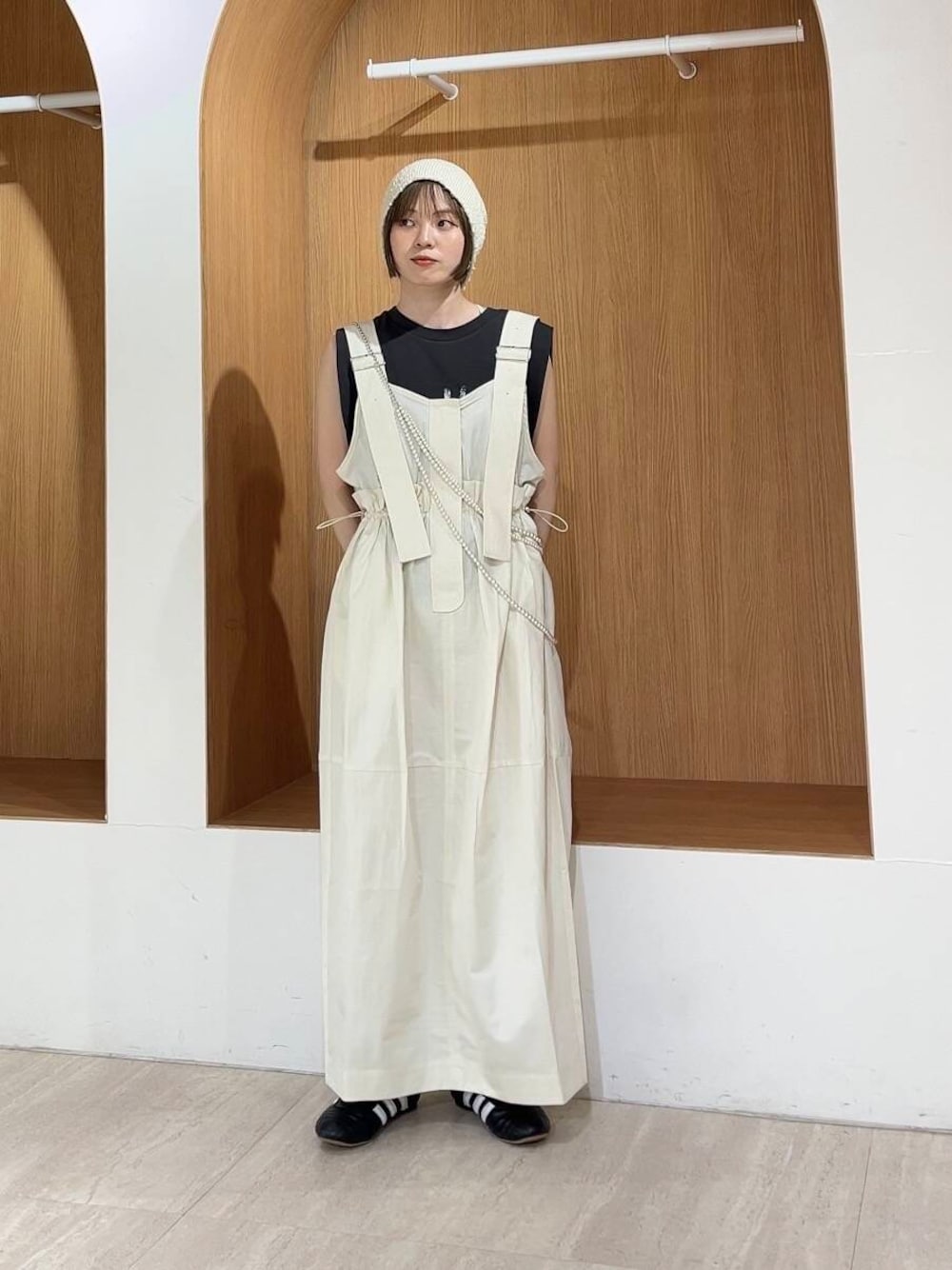 グレー系のTシャツ/カットソー、ホワイト系のワンピース、ブラック系のスニーカーを着用したレディースの春コーディネートの1枚目の写真
