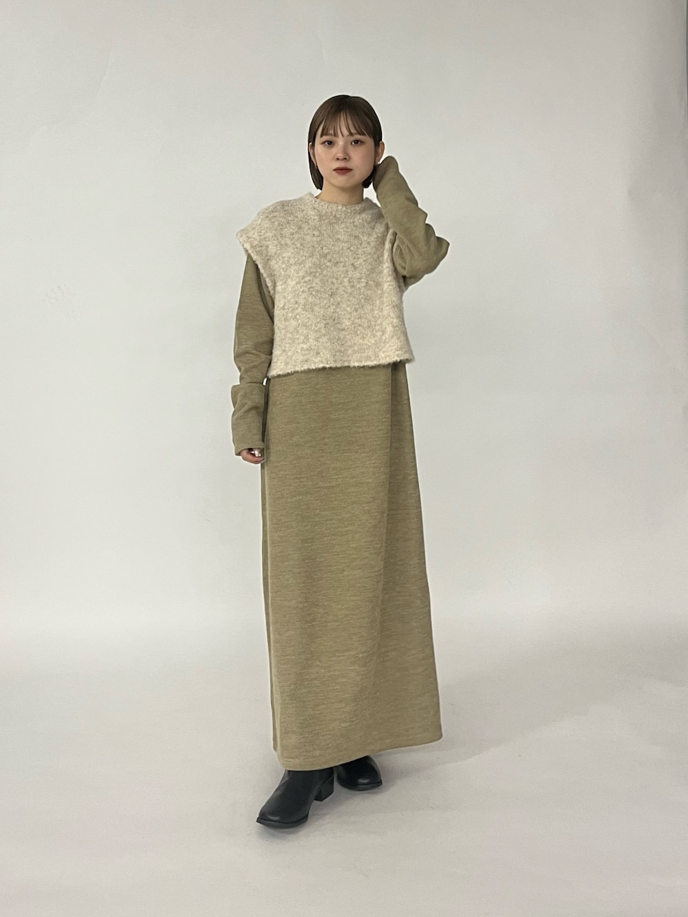 ベージュ系のワンピース、ブラック系のブーツを着用したレディースの秋コーディネートの1枚目の写真