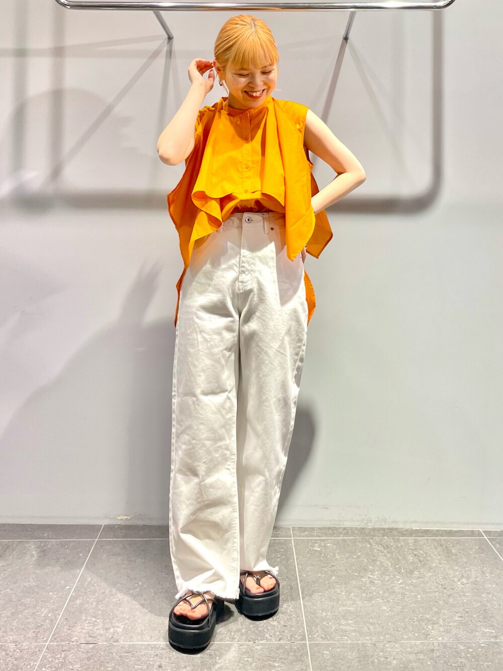 ブラック系のサンダル、ホワイト系のデニムパンツ、オレンジ系のシャツ/ブラウスを着用したレディースの夏コーディネートの1枚目の写真