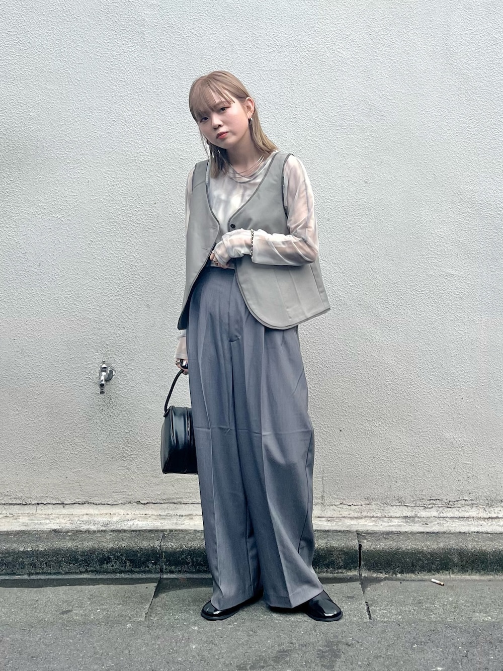 ブラック系のその他シューズ、ブラック系のハンドバッグ、グレー系のその他パンツを着用したレディースの夏コーディネートの1枚目の写真