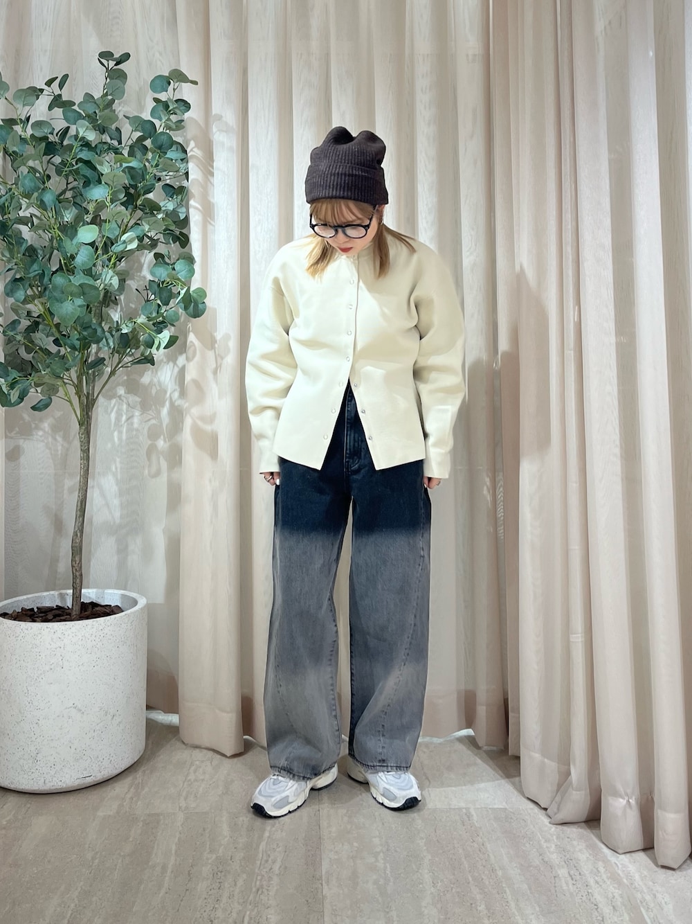 ブラック系のデニムパンツ、ベージュ系のカーディガン/ボレロを着用したレディースの冬コーディネートの1枚目の写真