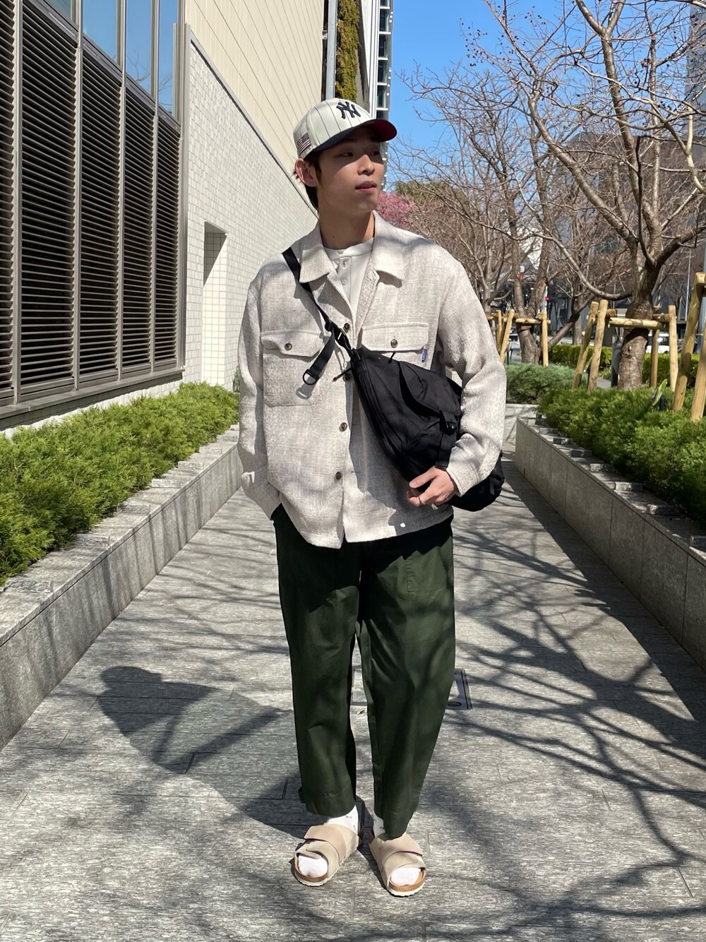 ベージュ系のその他アウター、グリーン系のその他パンツ、ベージュ系のサンダルを着用したメンズの春コーディネートの1枚目の写真