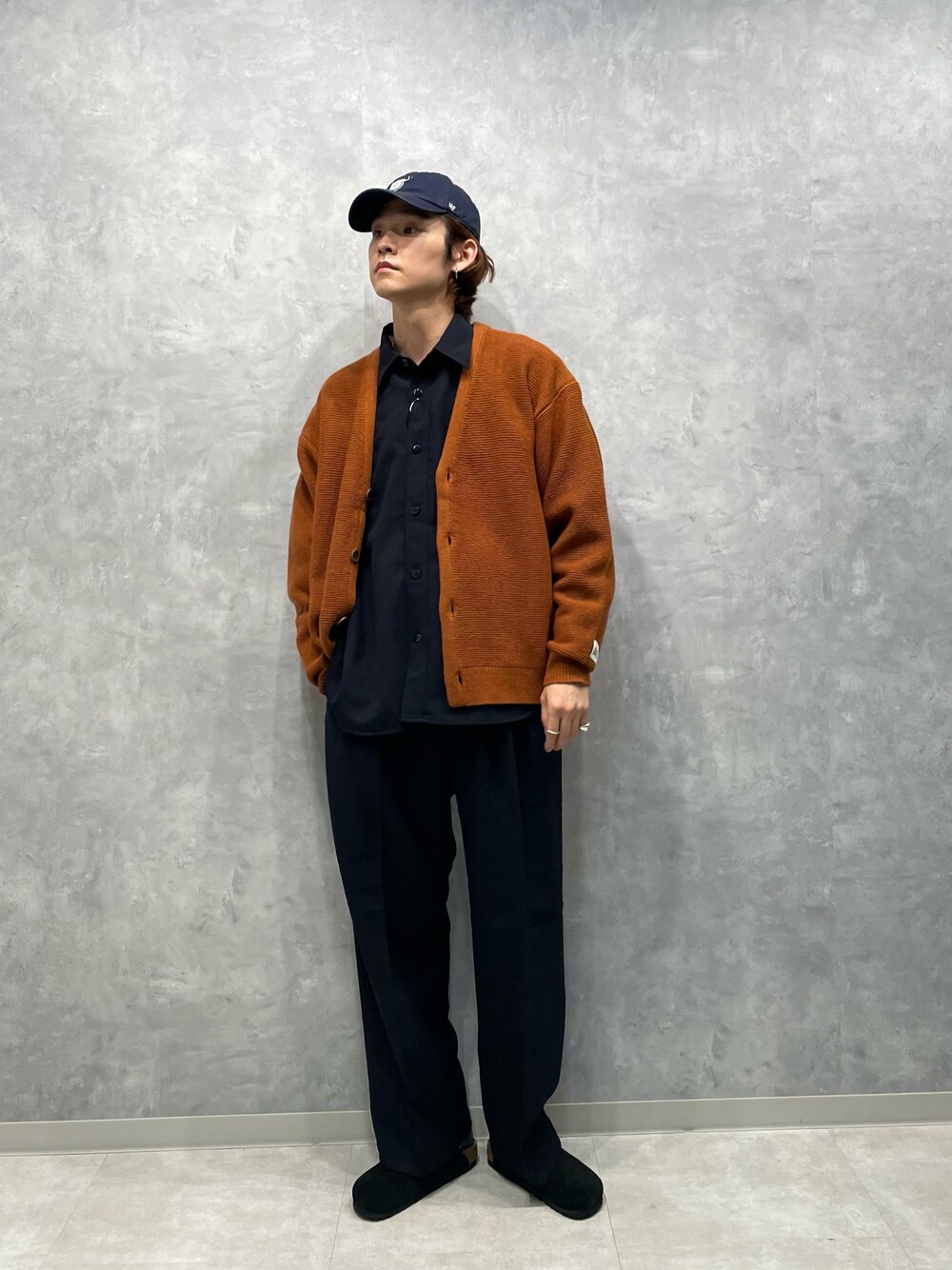 ブラウン系のカーディガン/ボレロ、ブルー系のシャツ/ブラウス、ブルー系のスラックスを着用したメンズの秋コーディネートの1枚目の写真