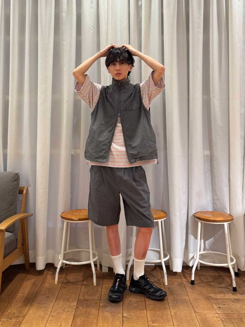 グレー系のベスト、グレー系のその他パンツ、ブラック系のスニーカーを着用したメンズの春コーディネートの1枚目の写真