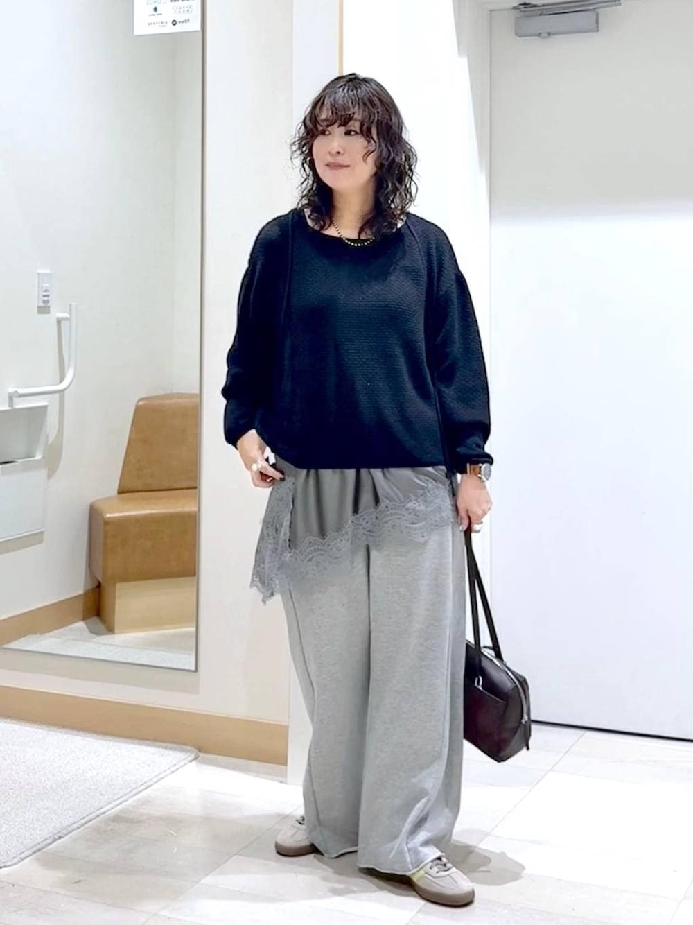 グレー系のスウェットパンツ、ブラック系のタンクトップ、ブラウン系のショルダーバッグを着用したレディースの春コーディネートの1枚目の写真