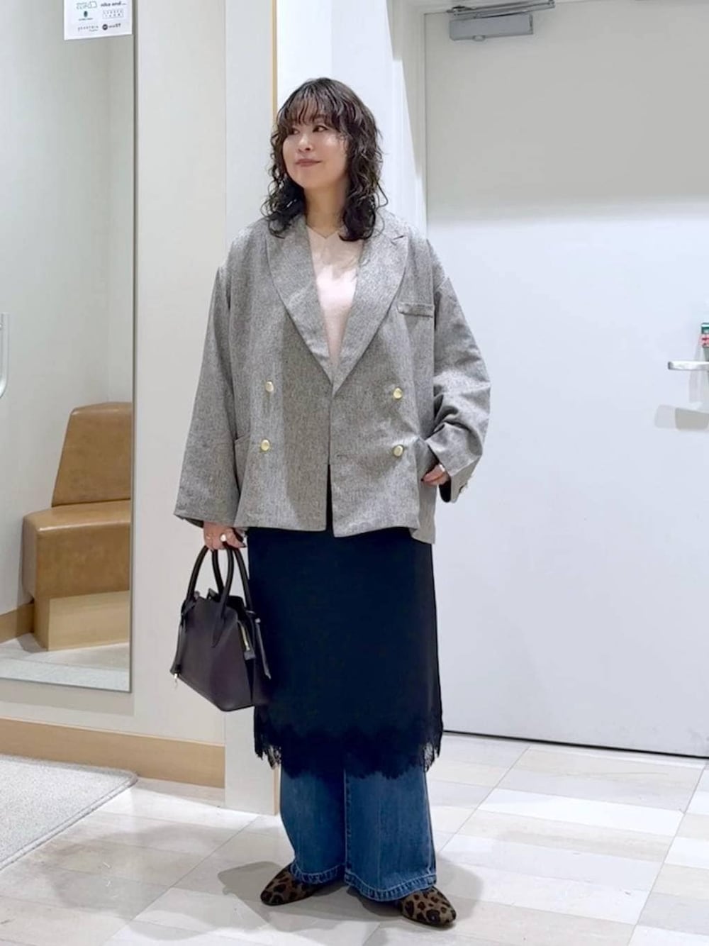 その他のパンプス、ブラウン系のショルダーバッグ、ブルー系のデニムパンツを着用したレディースの春コーディネートの1枚目の写真