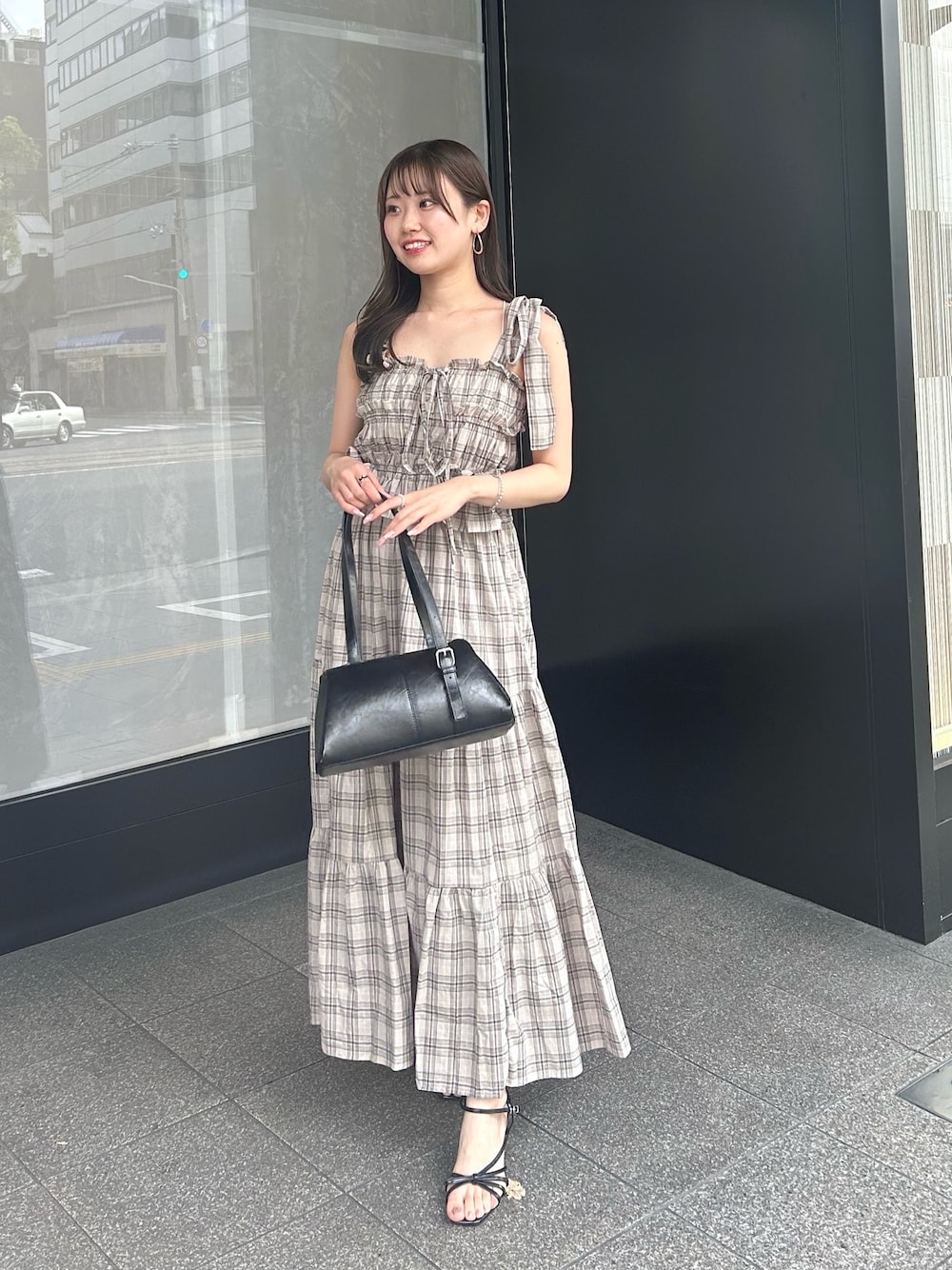 ベージュ系のワンピース、ブラック系のボストンバッグ、ブラック系のサンダルを着用したレディースの夏コーディネートの1枚目の写真
