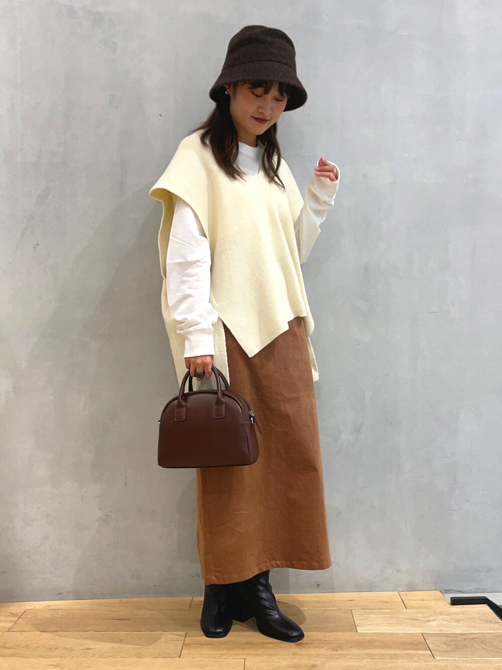ホワイト系のニット/セーター、ホワイト系のTシャツ/カットソー、イエロー系のスカートを着用したレディースの秋コーディネートの1枚目の写真