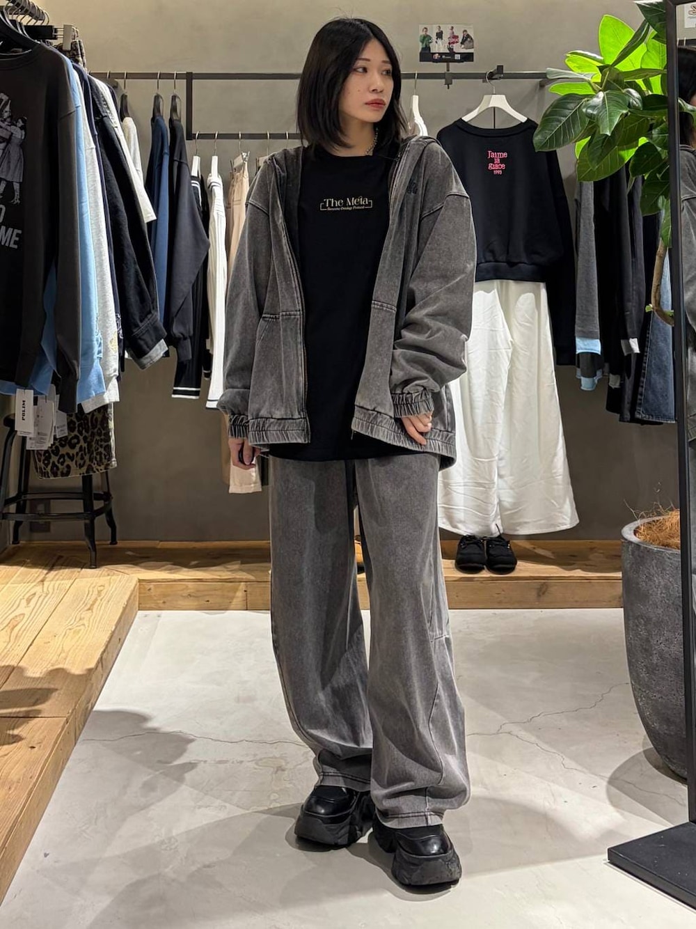 ブラック系のブーツ、ブラック系のデニムパンツ、ブラック系のパーカーを着用したレディースの春コーディネートの1枚目の写真