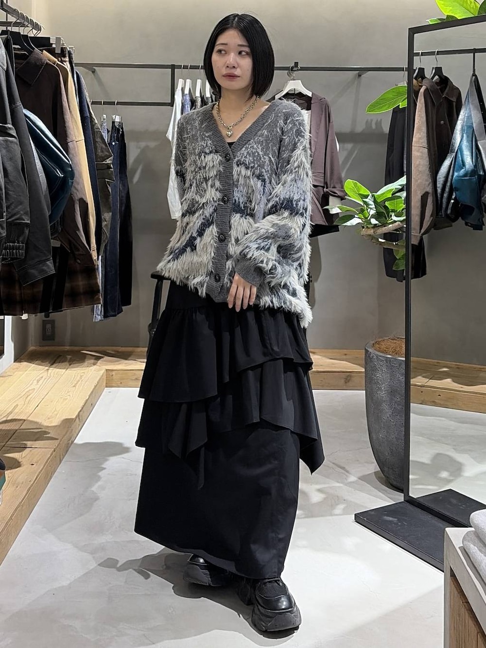 ブラック系のブーツ、ブラック系のキャミソール、ブラック系のスカートを着用したレディースの秋コーディネートの1枚目の写真