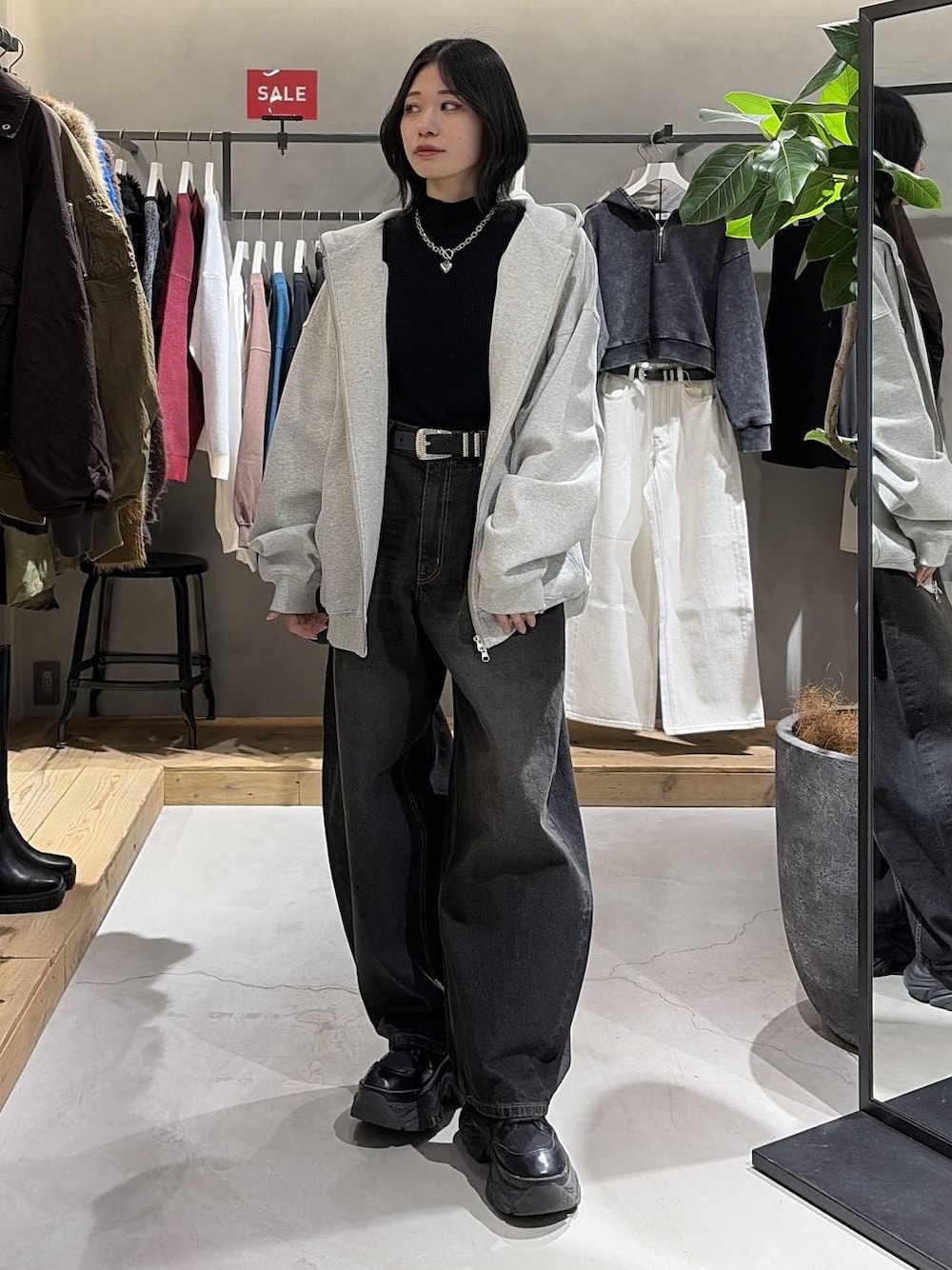 ブラック系のブーツ、グレー系のパーカー、ブラック系のデニムパンツを着用したレディースの冬コーディネートの1枚目の写真