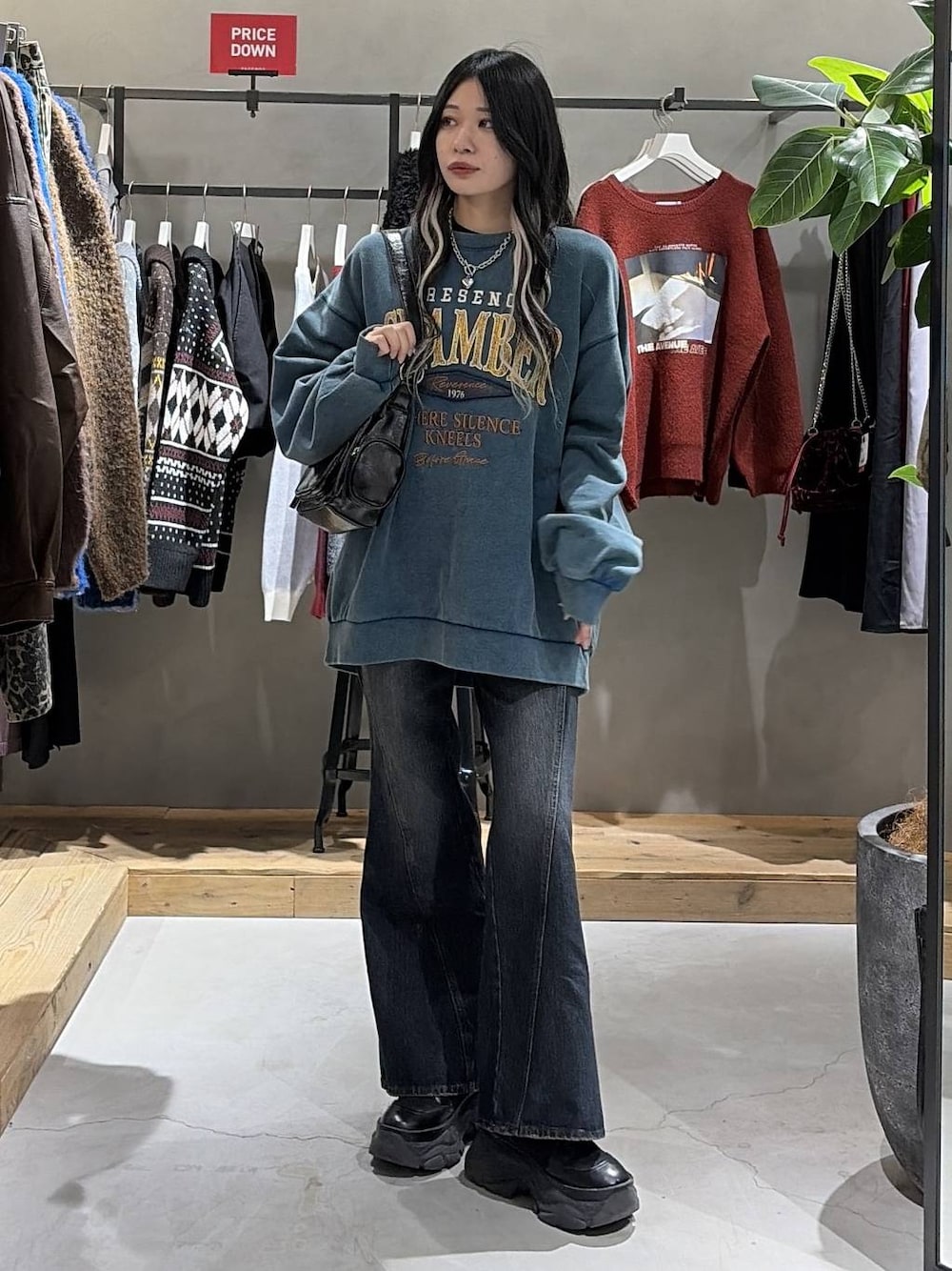 ブラック系のブーツ、ブルー系のデニムパンツ、グリーン系のスウェットを着用したレディースの冬コーディネートの1枚目の写真