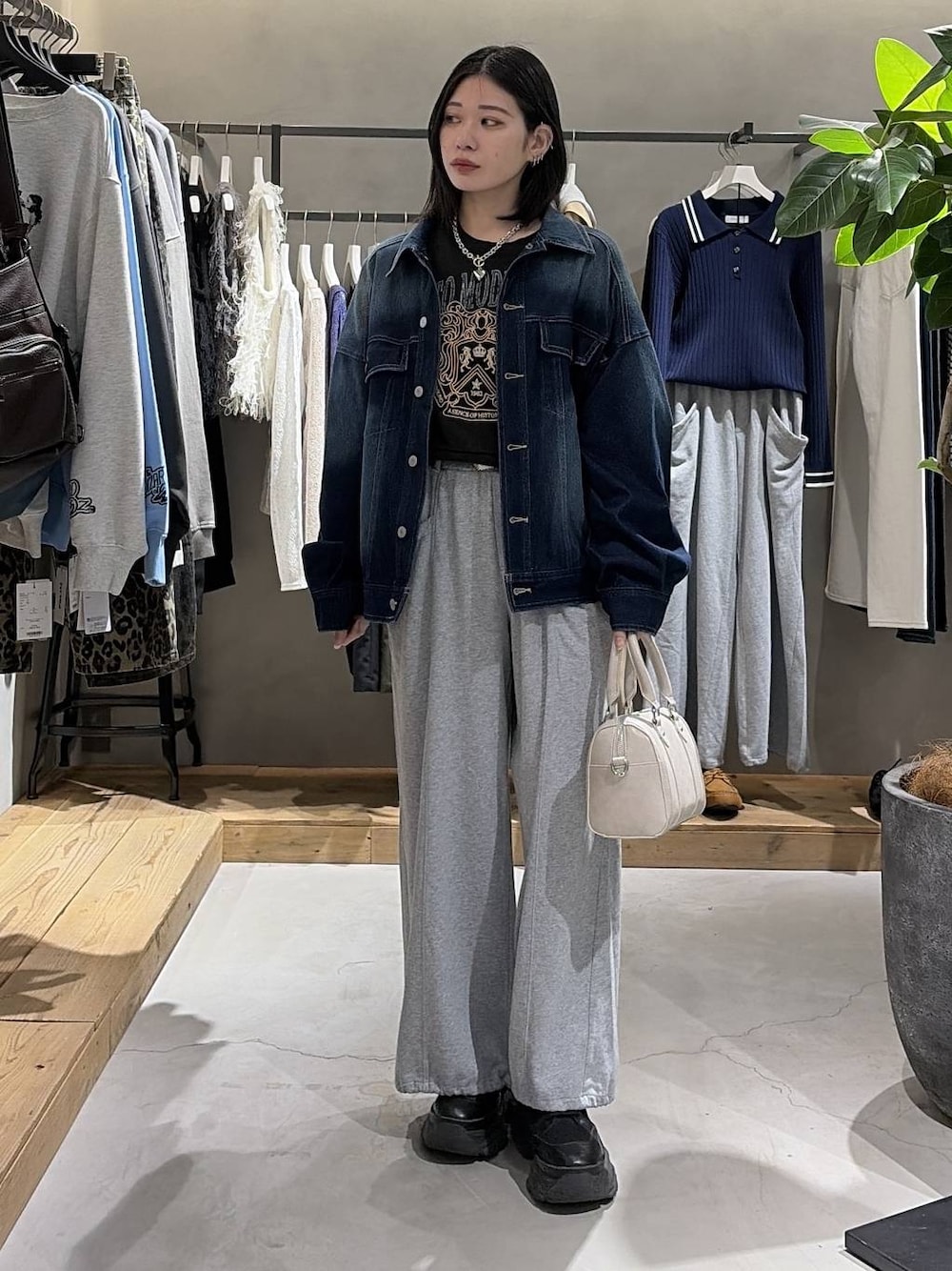 ブラック系のブーツ、ホワイト系のボストンバッグ、グレー系のスウェットを着用したレディースの冬コーディネートの1枚目の写真