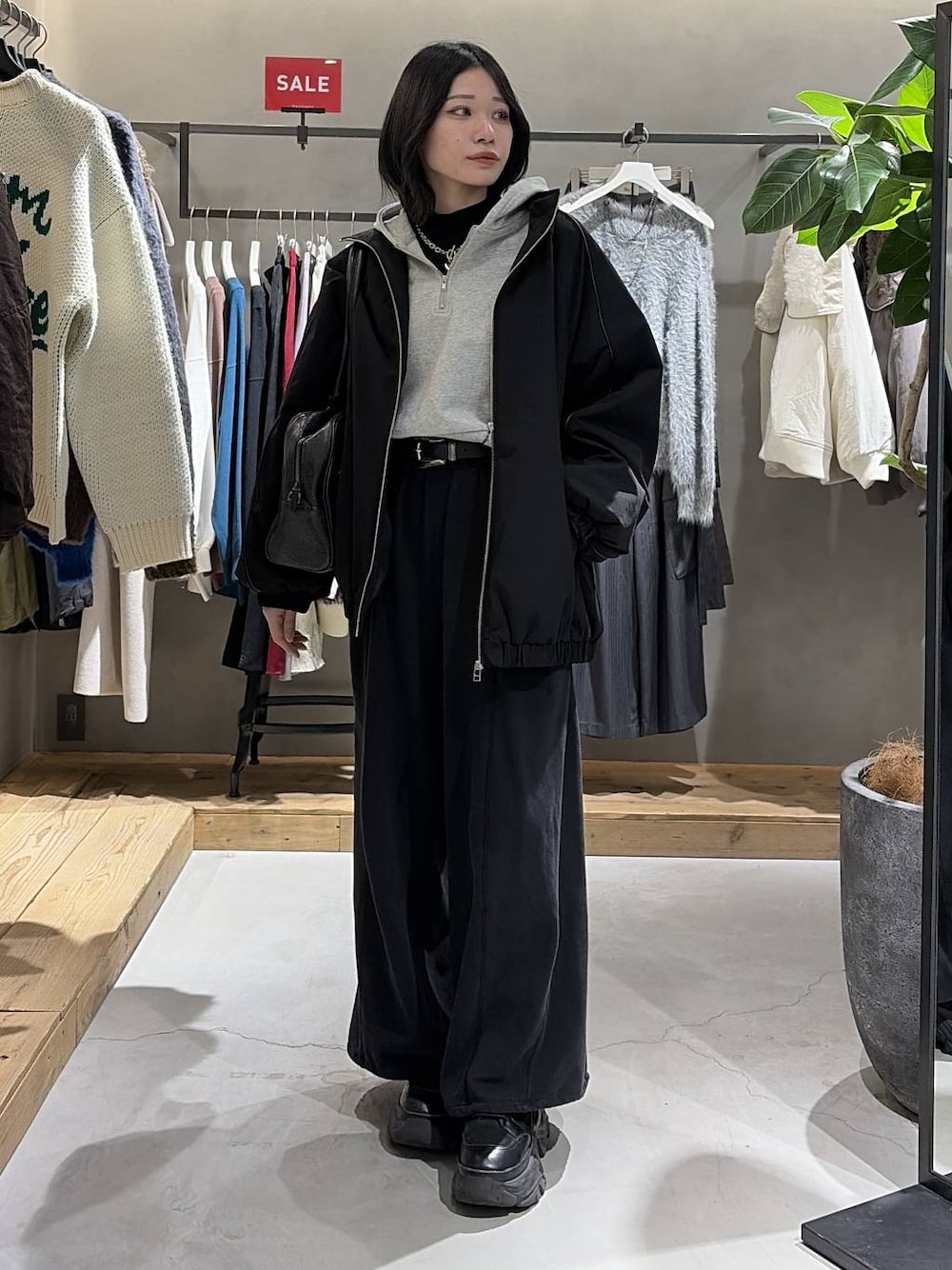 ブラック系のブーツ、ブラック系のニット/セーター、ブラック系のナイロンジャケットを着用したレディースの冬コーディネートの1枚目の写真