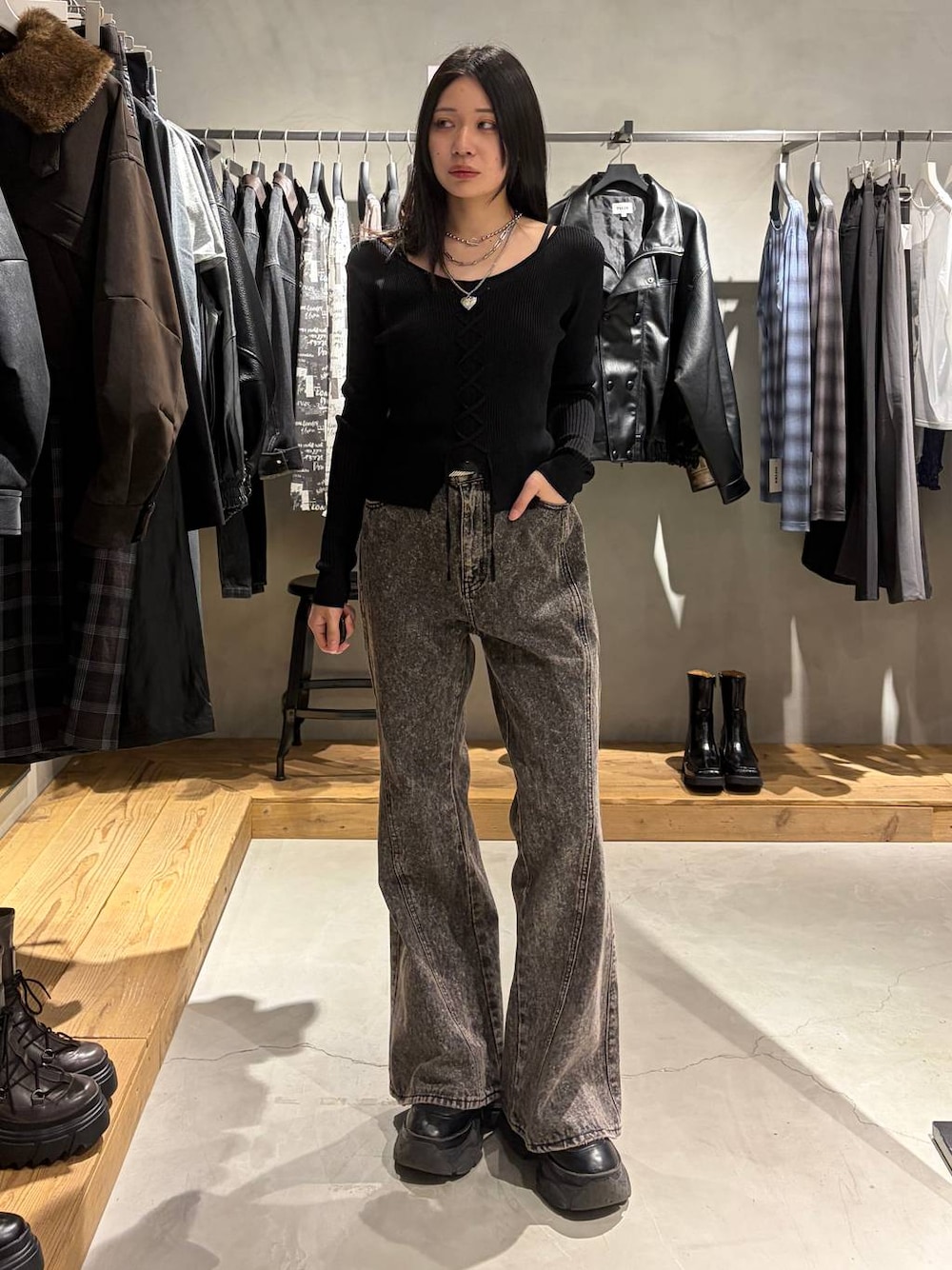 ブラック系のニット/セーター、ブラック系のデニムパンツ、シルバー系のネックレスを着用したレディースの秋コーディネートの1枚目の写真