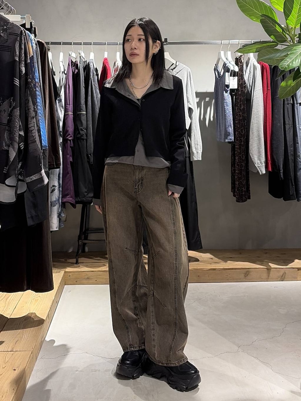 ブラウン系のデニムパンツ、ブラック系のスニーカー、ブラック系のカーディガン/ボレロを着用したレディースの秋コーディネートの1枚目の写真