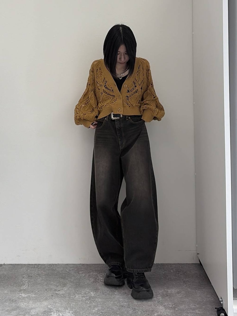 イエロー系のカーディガン/ボレロ、ブラック系のデニムパンツ、シルバー系のネックレスを着用したレディースの冬コーディネートの1枚目の写真