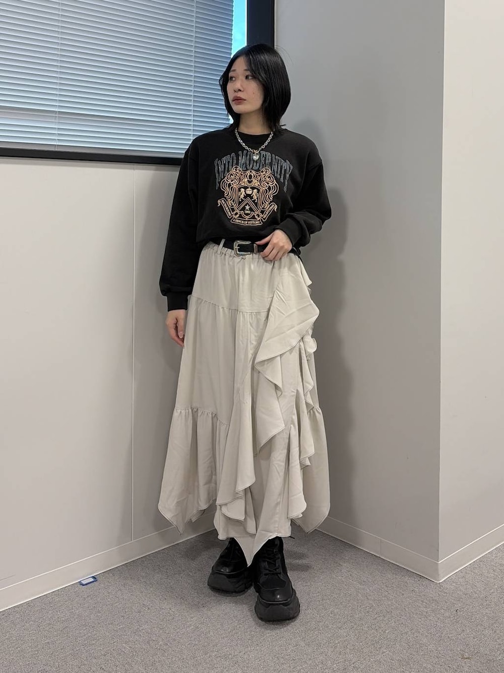 ブラック系のブーツ、ベージュ系のスカート、グレー系のスウェットを着用したレディースの冬コーディネートの1枚目の写真