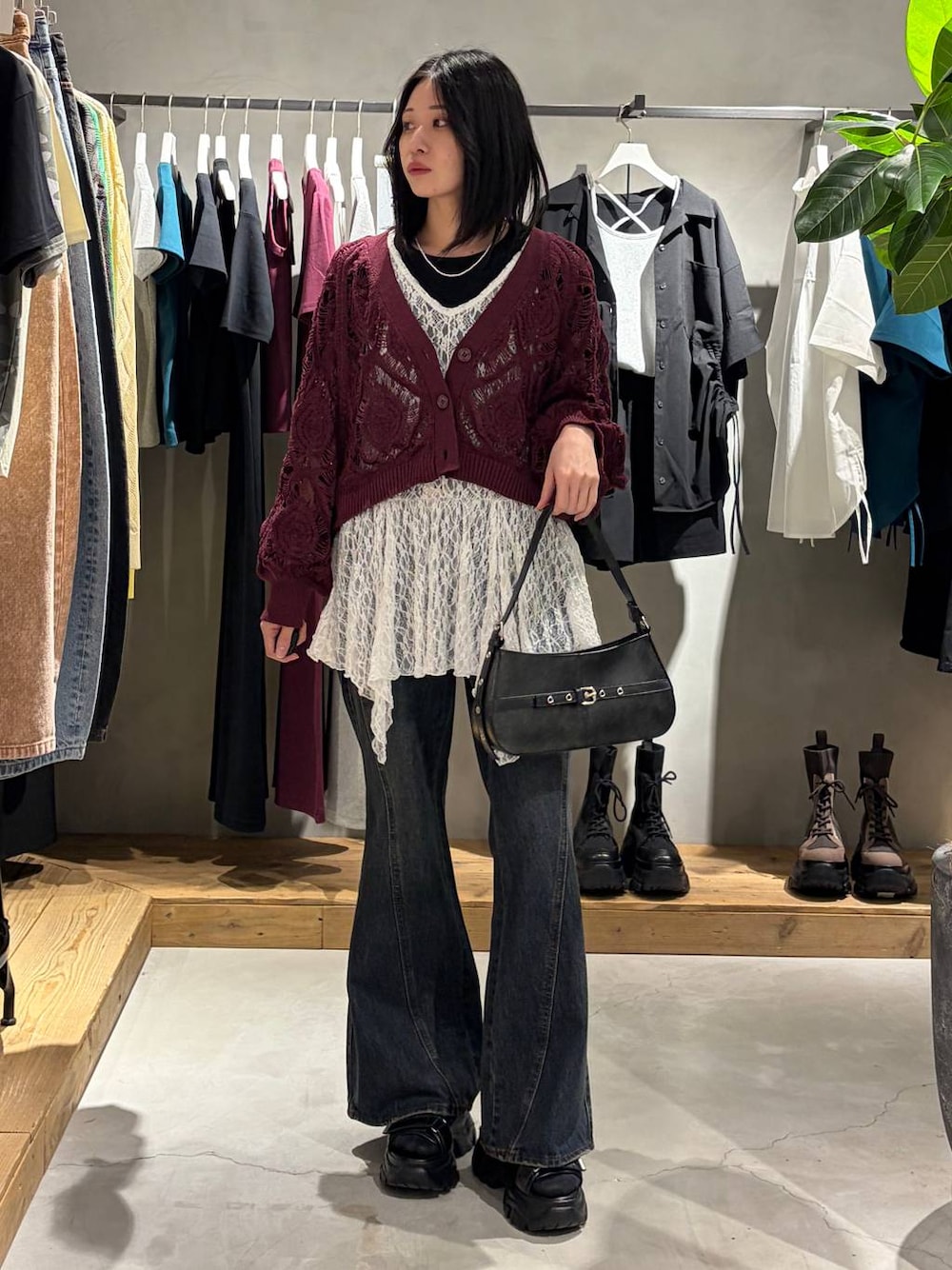 パープル系のカーディガン/ボレロ、ブルー系のデニムパンツ、ブラック系のハンドバッグを着用したレディースの春コーディネートの1枚目の写真