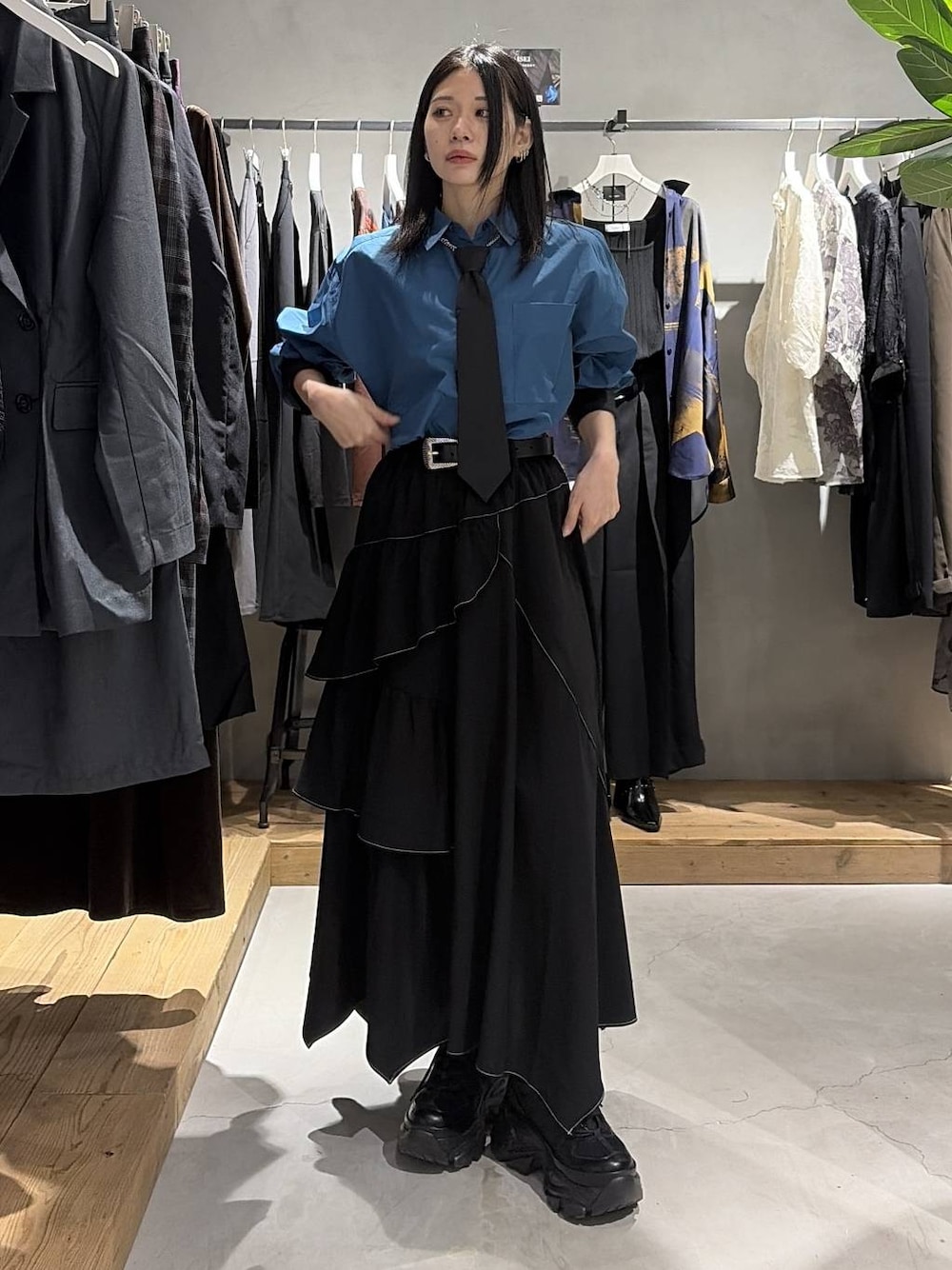ブラック系のスカート、ブルー系のシャツ/ブラウス、ブラック系のスニーカーを着用したレディースの夏コーディネートの1枚目の写真