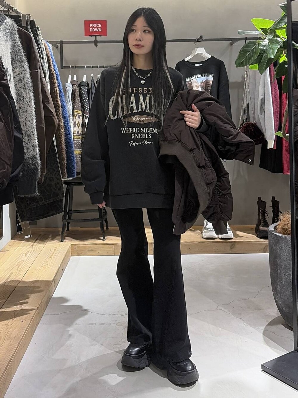 ブラック系のブーツ、ブラック系のデニムパンツ、グレー系のスウェットを着用したレディースの冬コーディネートの1枚目の写真