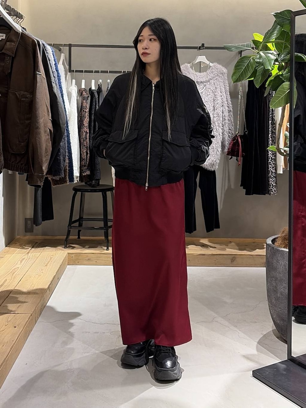 ブラック系のブーツ、ブラック系のブルゾン、レッド系のスカートを着用したレディースの冬コーディネートの1枚目の写真