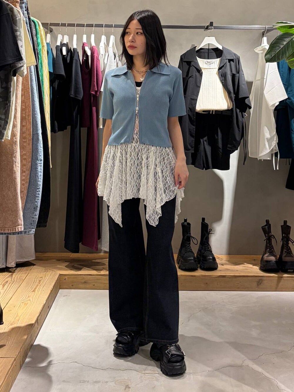 ブルー系のデニムパンツ、ブラック系のサンダル、ホワイト系のチュニックを着用したレディースの春コーディネートの1枚目の写真