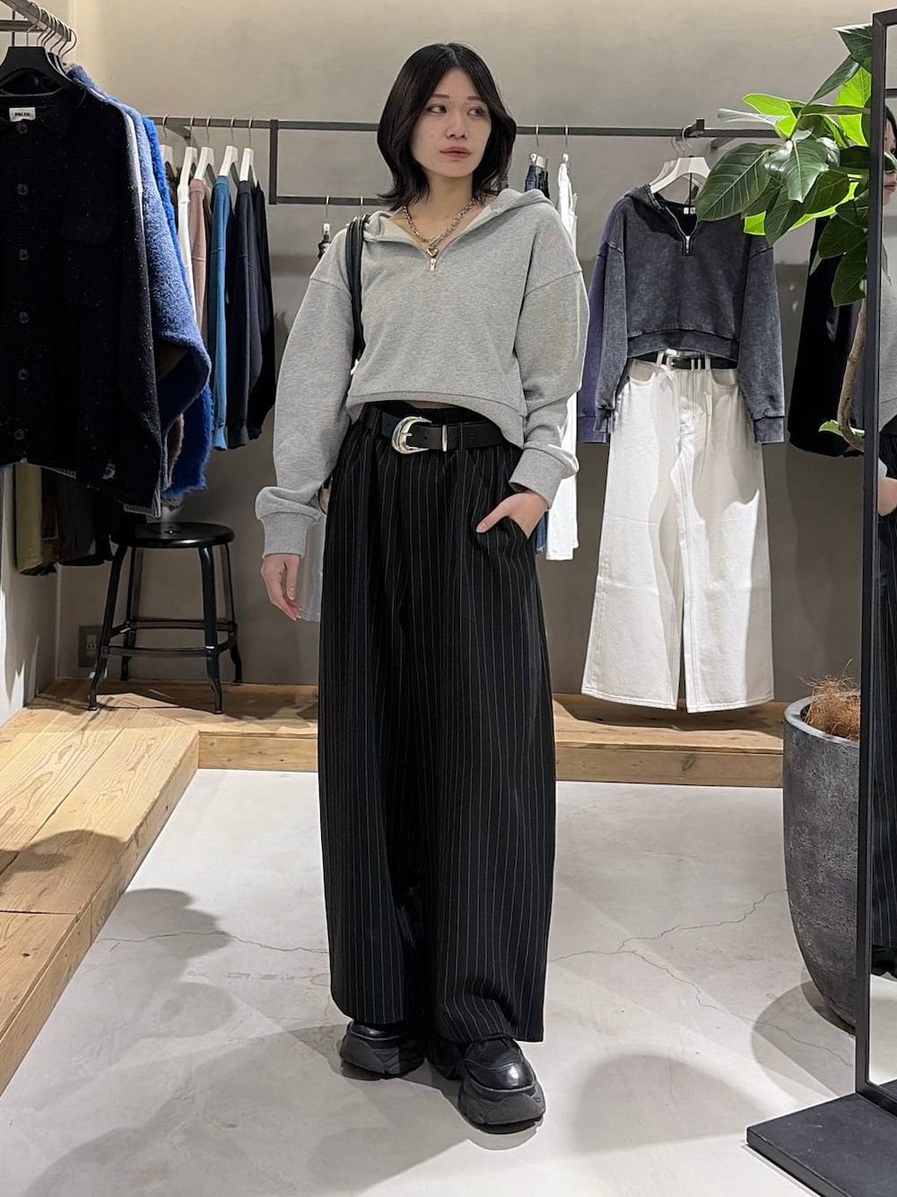 ブラック系のブーツ、ブラック系のボストンバッグ、グレー系のパーカーを着用したレディースの冬コーディネートの1枚目の写真