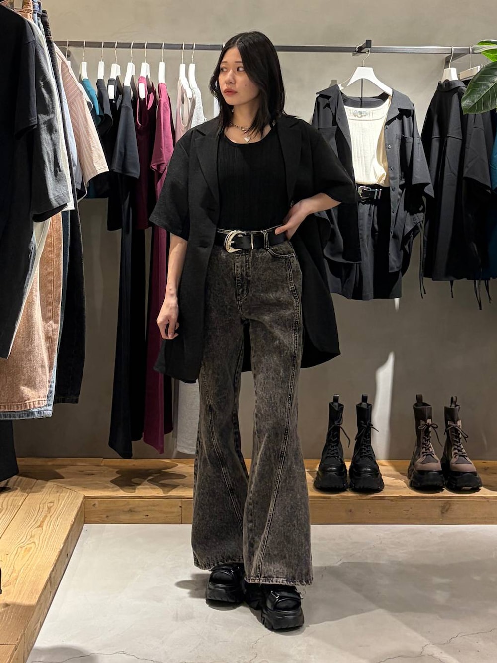 ブラック系のデニムパンツ、ブラック系のサンダル、ブラック系のテーラードジャケットを着用したレディースの春コーディネートの1枚目の写真