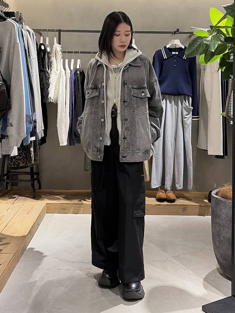 ブラック系のブーツ、グレー系のパーカー、ブラック系のブルゾンを着用したレディースの冬コーディネートの1枚目の写真